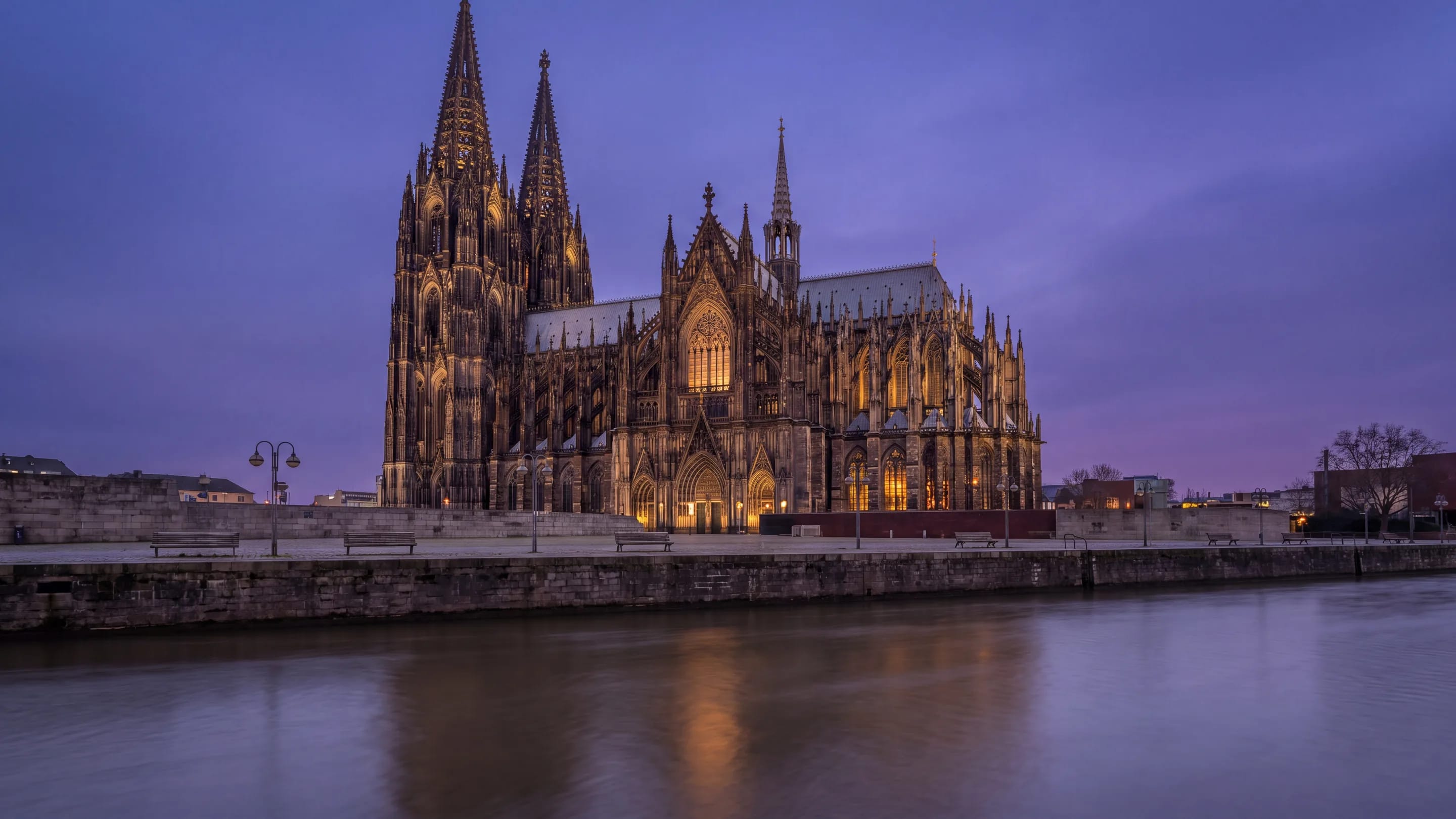 Eine gotische Kathedrale in der Abenddämmerung, vom gegenüberliegenden Flussufer aus gesehen.